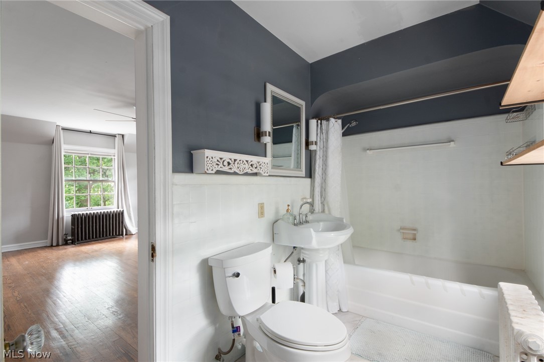 3133 Keswick Road Cleveland, OH 44120 - Photo 23 of 35 Bathroom featuring wood-type flooring, radiator, toilet, and shower / tub combo with curtain