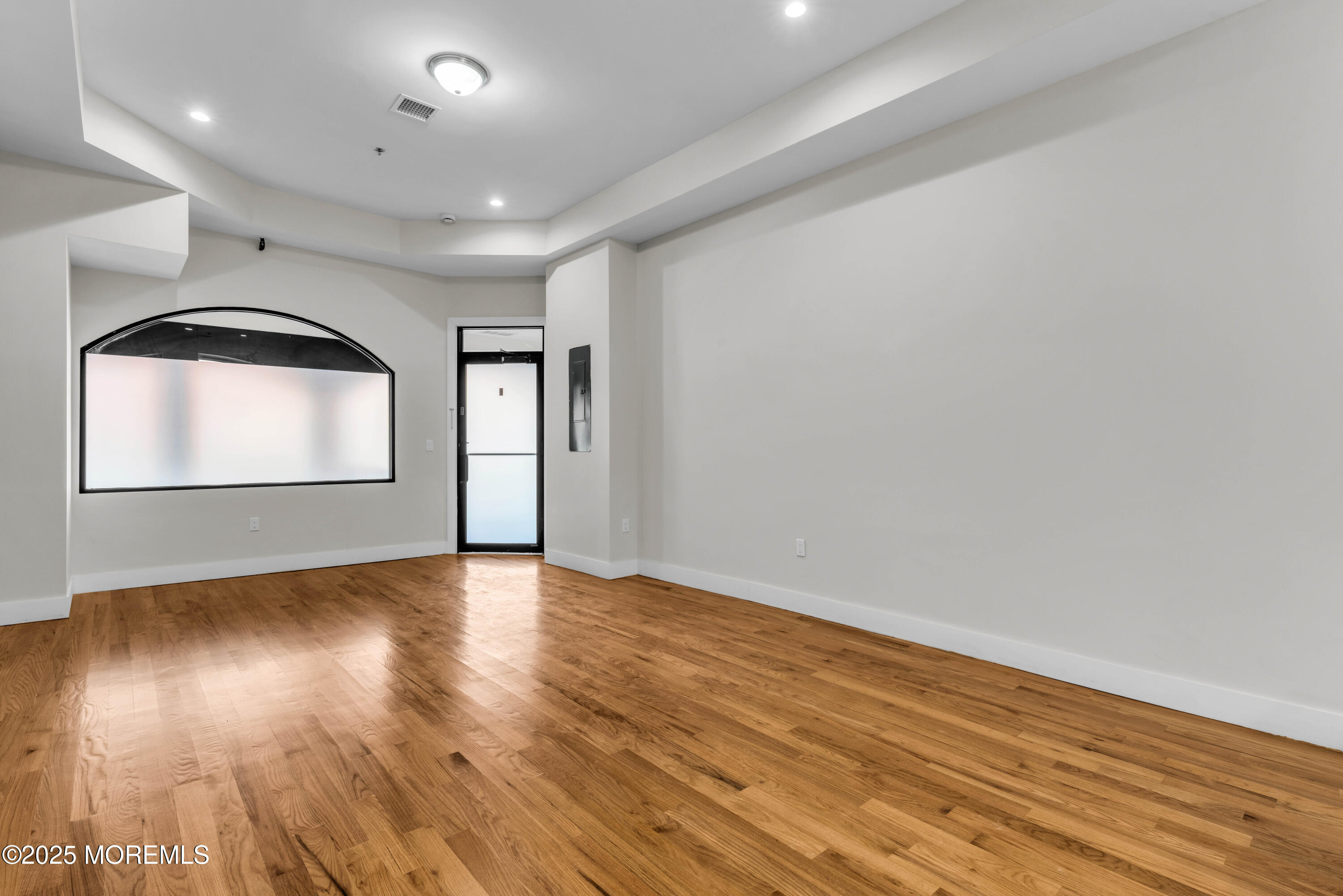 7 Broad Street, Unit 2 Red Bank, NJ 07701 - Photo 2 of 23 an empty room with wooden floor and windows