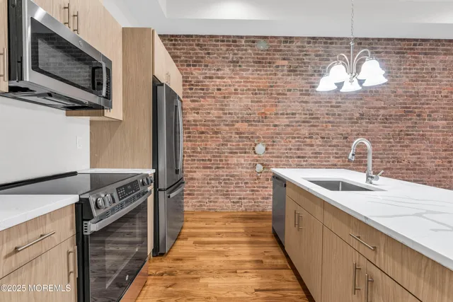 a kitchen with stainless steel appliances granite countertop a sink and a microwave
