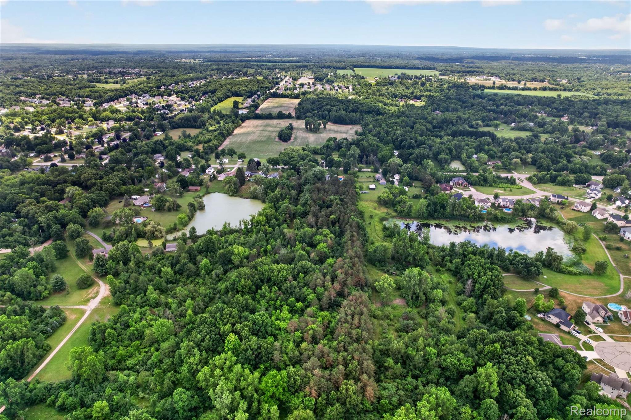 1437 East Cook Road Grand Blanc, MI 48439 - Photo 25 of 69 Expansive aerial landscape featuring a large body of water, dense tree coverage, scattered residential properties, open fields, and paved roads