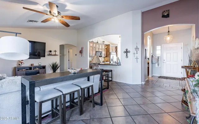 a view of a a dining room with furniture and a chandelier fan