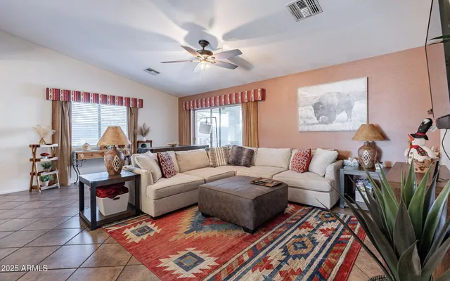 a living room with furniture a large window and a chandelier