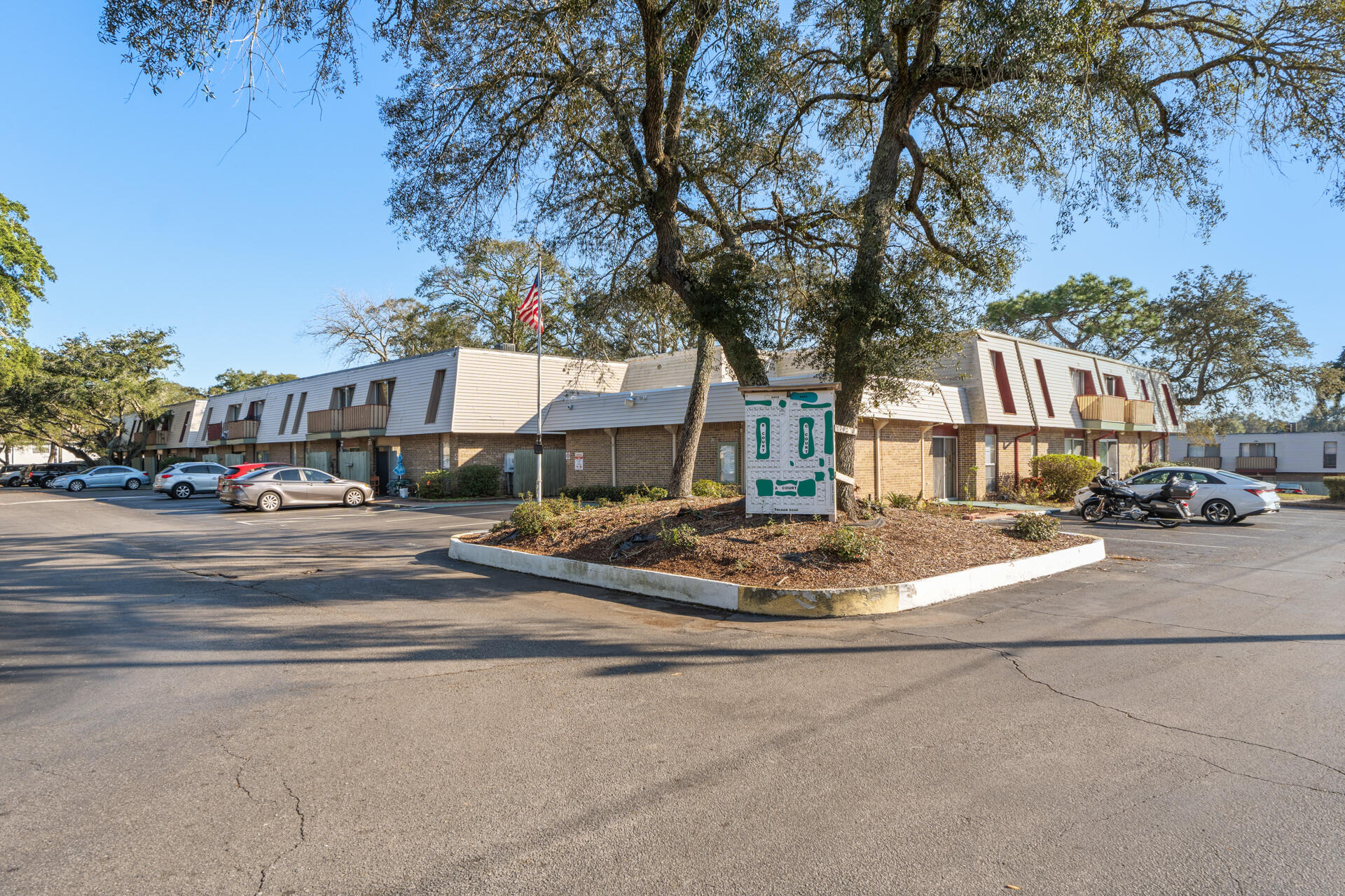 210 Pelham Road, Unit 220A Fort Walton Beach, FL 32547 - Photo 4 of 38 a building exterior with tall trees
