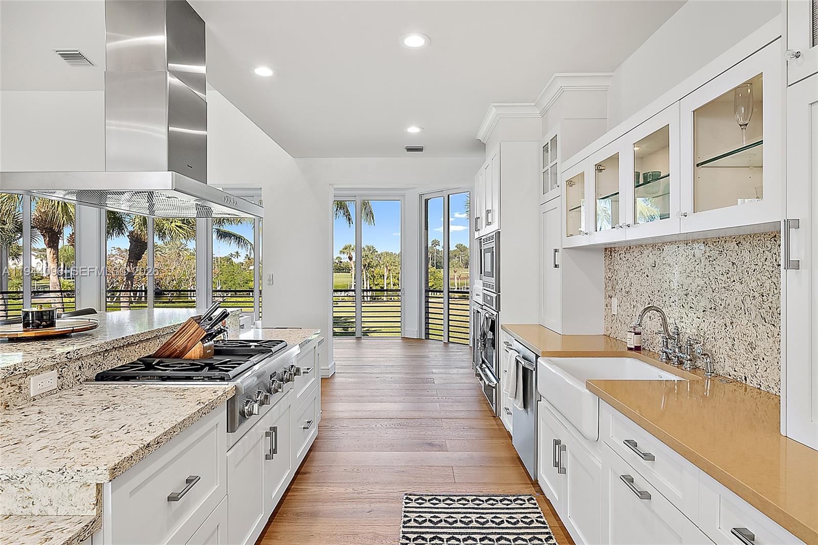 1602 Captains Way Jupiter, FL 33477 - Photo 6 of 35 a large kitchen with stainless steel appliances a large counter top a stove a sink and a refrigerator