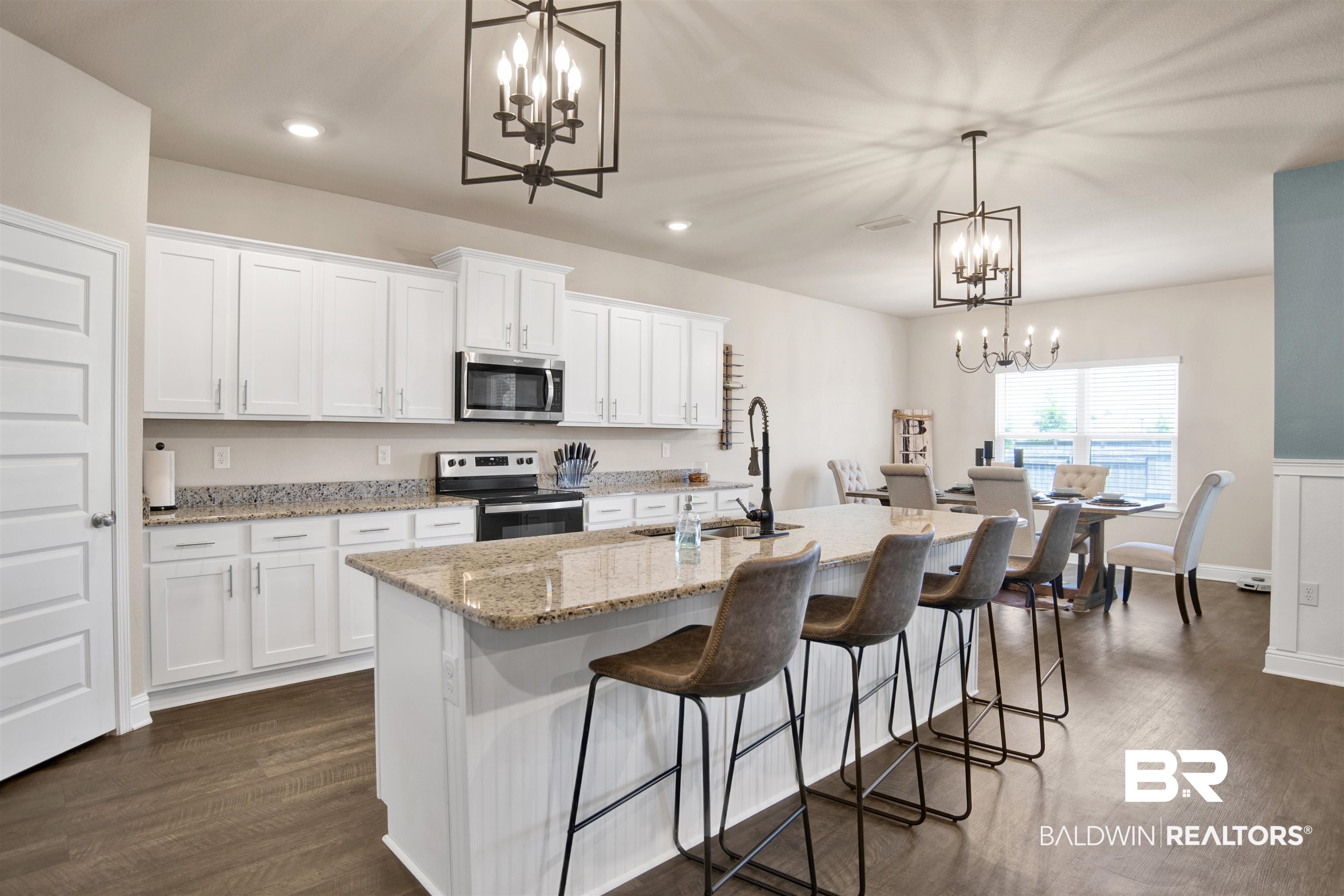 8493 Bronze Lane Foley, AL 36535 - Photo 11 of 38 Open-concept kitchen and dining area featuring a granite island, white cabinetry, dark wood-finish flooring, recessed lighting, and contemporary chandeliers
