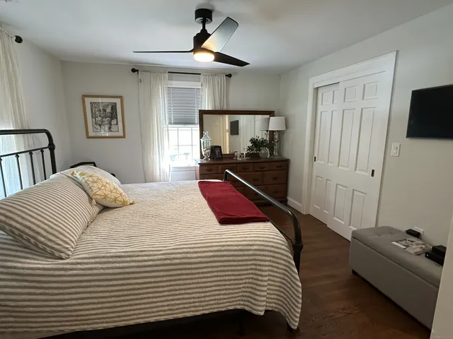 a bedroom with a bed a couch and a chandelier