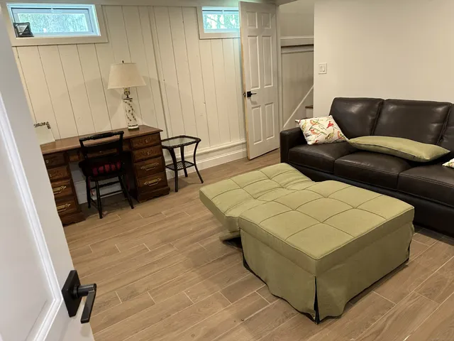a living room with furniture and a wooden floor