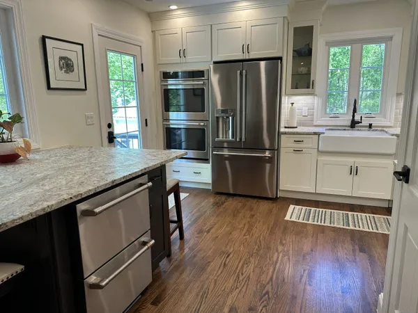 a kitchen with granite countertop a refrigerator and a stove top oven