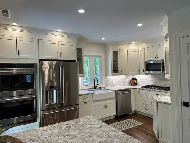 a kitchen with stainless steel appliances kitchen island granite countertop a refrigerator stove and sink