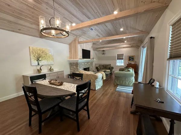 a view of a dining room with furniture a chandelier and wooden floor
