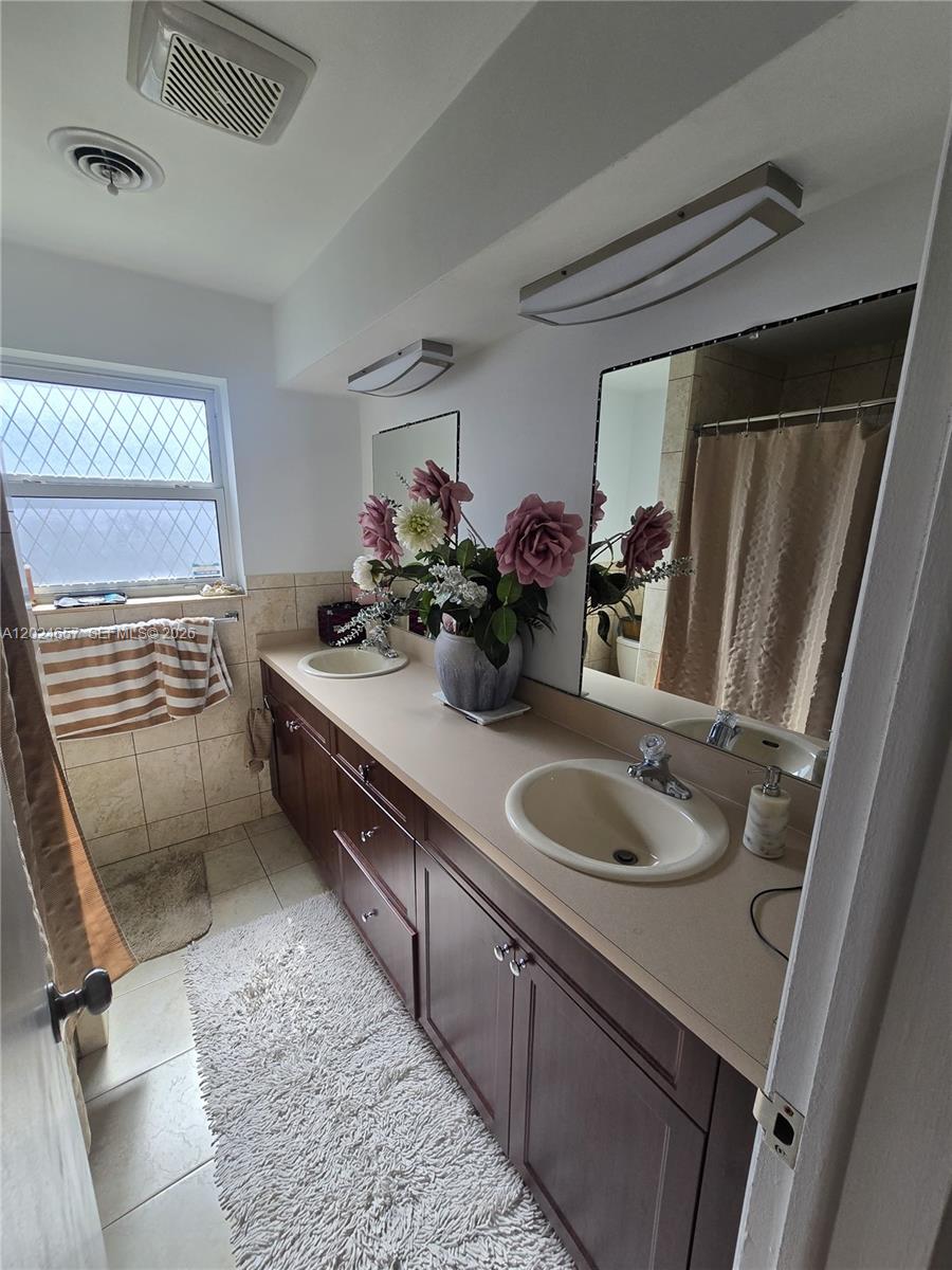 3619 West Park Road Hollywood, FL 33021 - Photo 13 of 19 a bathroom with a sink double vanity and a mirror