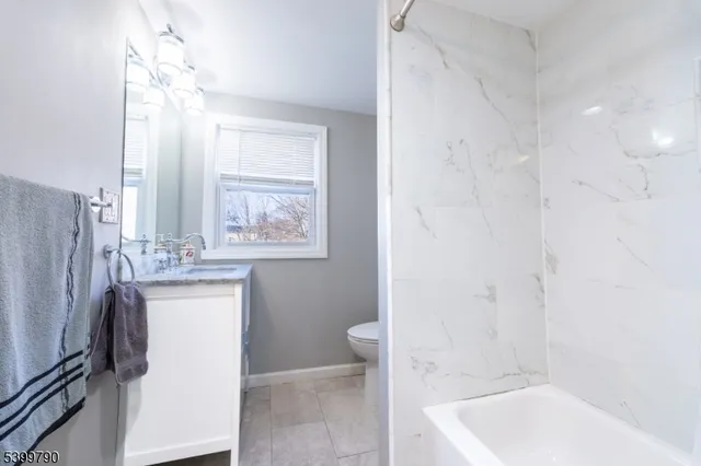a bathroom with a tub sink and mirror