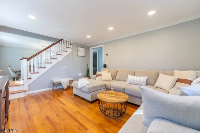 a living room with furniture and a dining table with wooden floor