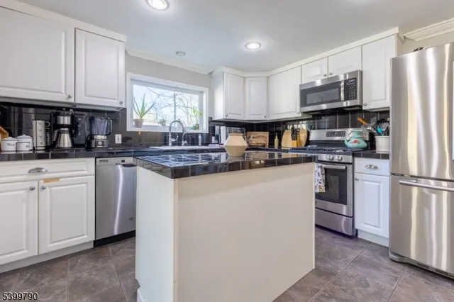a kitchen with white cabinets and white appliances