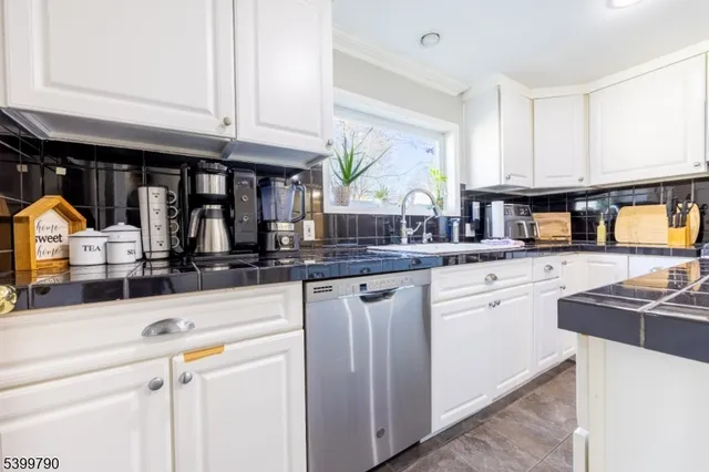 a kitchen with stainless steel appliances granite countertop a sink and a stove