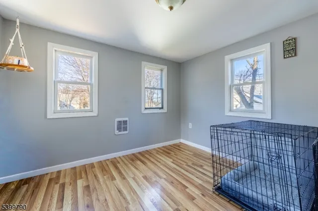 a view of a bedroom with wooden floor and windows