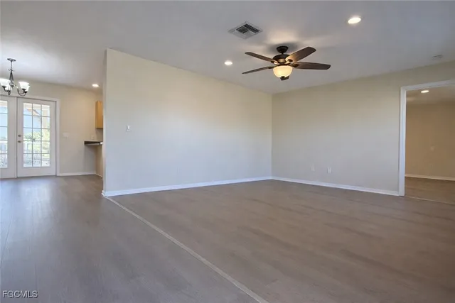 a view of a room with a ceiling fan and wooden floor