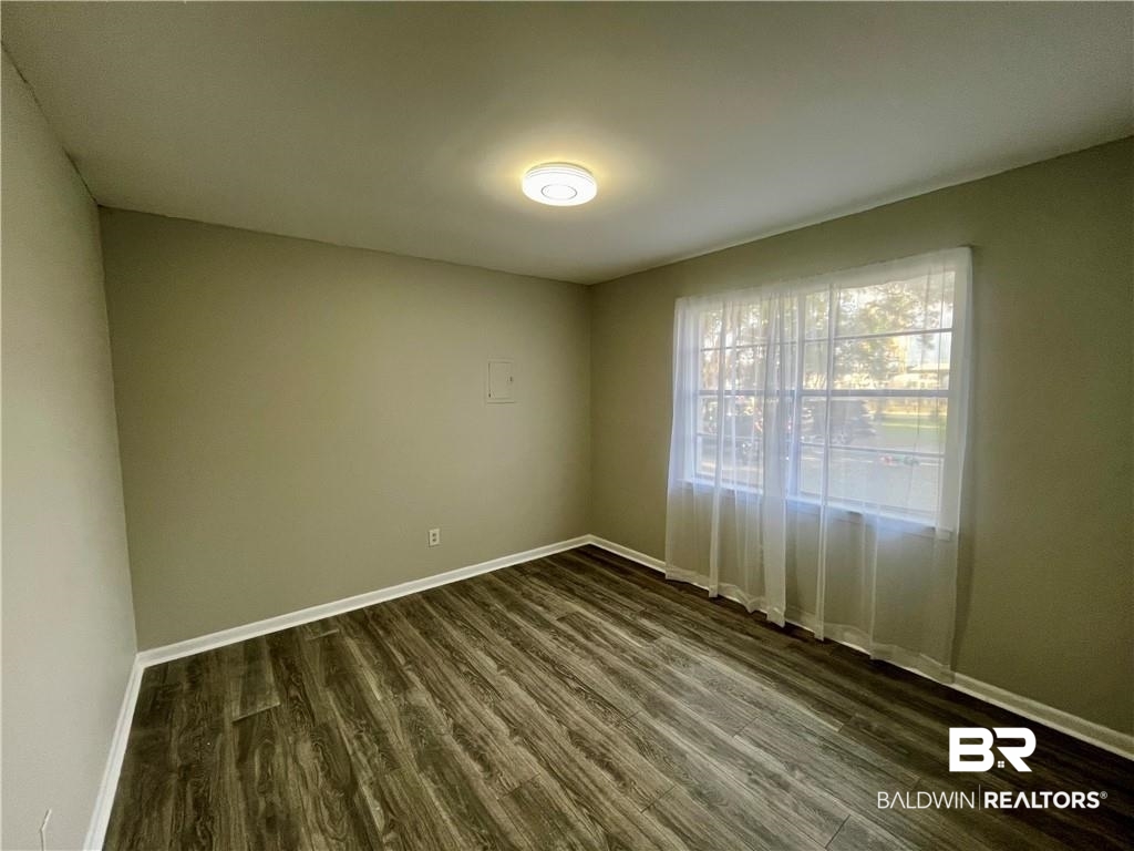 8636 Boe Road Irvington, AL 36544 - Photo 21 of 22 Unfurnished room with baseboards and dark wood-style flooring