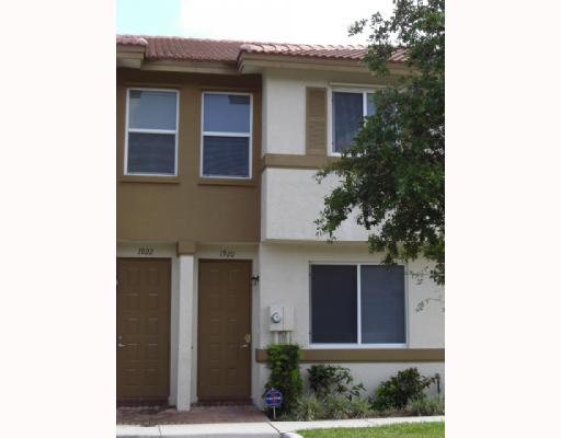1920 Hibiscus Lane, Unit 163 Riviera Beach, FL 33404 - Photo 1 of 16 a front view of a house with plants