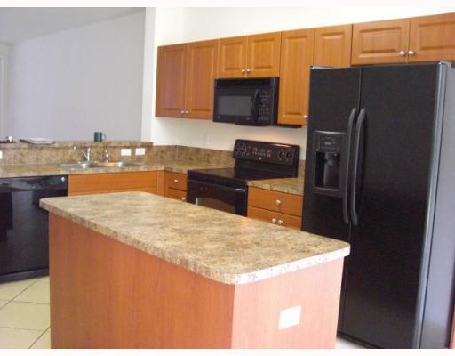 1920 Hibiscus Lane, Unit 163 Riviera Beach, FL 33404 - Photo 2 of 16 a kitchen with granite countertop a refrigerator stove and sink