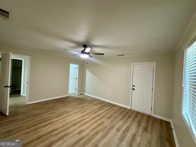 a view of an empty room with glass door and a window
