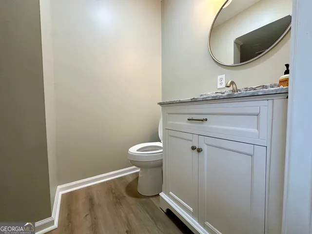 a bathroom with a toilet a sink and mirror