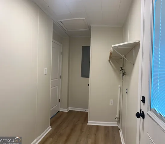 a view of a hallway with wooden floor and closet
