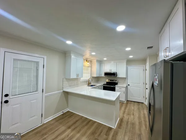 a kitchen with a refrigerator a sink and cabinets