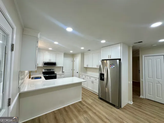 a kitchen with stainless steel appliances a refrigerator sink and microwave