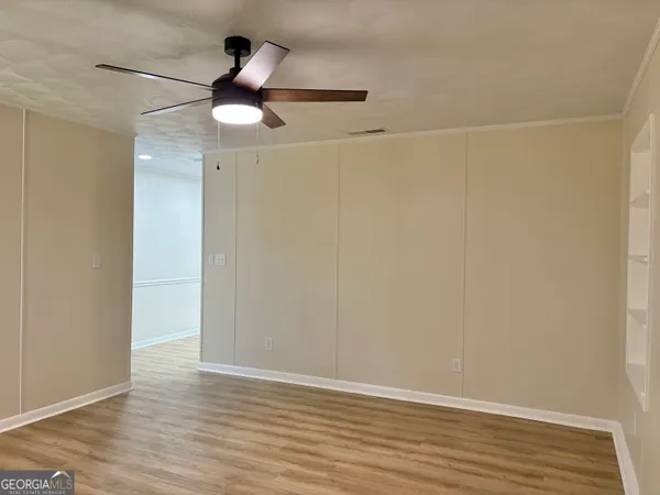 a view of empty room with wooden floor