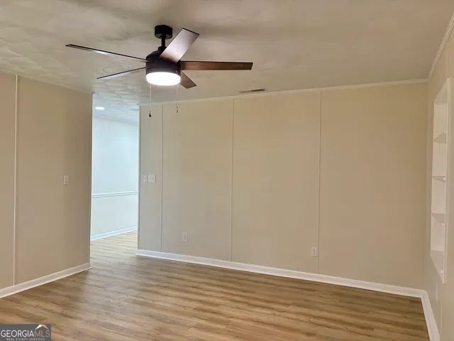 a view of empty room with wooden floor
