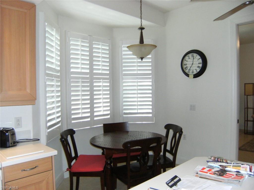 713 Regency Reserve Circle, Unit 5902 Naples, FL 34119 - Photo 4 of 9 a view of a dining room with furniture a chandelier and a large window