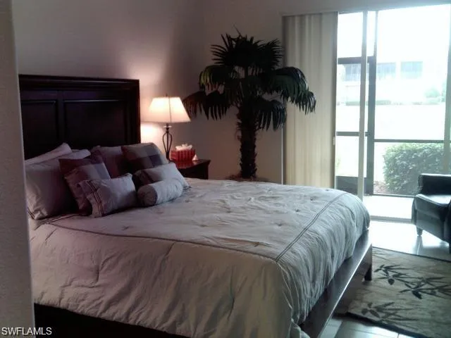 a bedroom with a bed window and potted plant