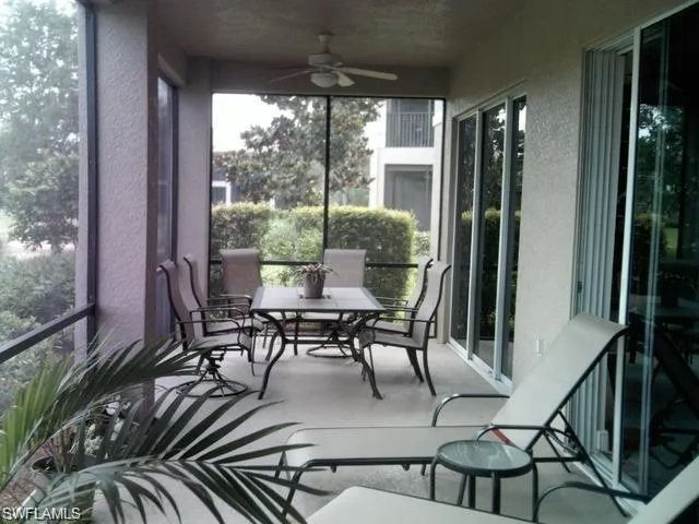 a view of a patio with table and chairs and floor to ceiling window