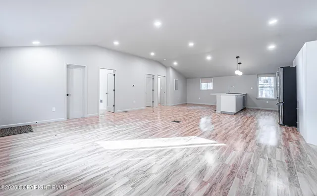 a view of a big room with wooden floor and a window