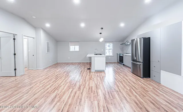 a view of kitchen view wooden floor and stainless steel appliances