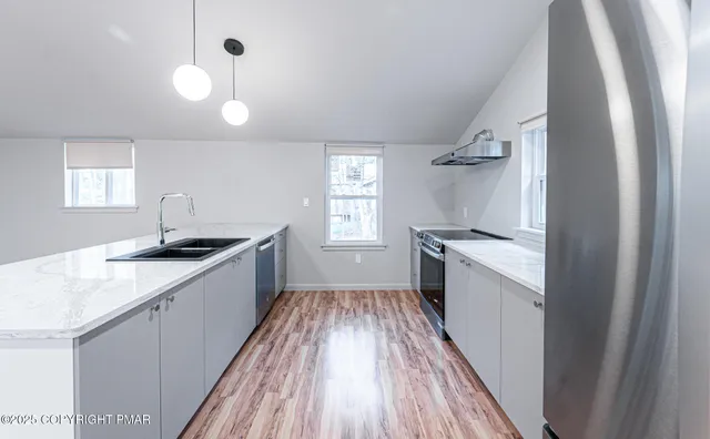 a kitchen with a sink and wooden floor