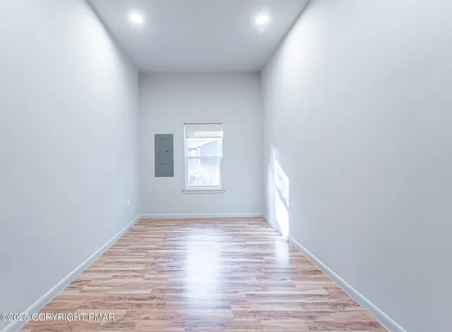 a view of empty room with wooden floor