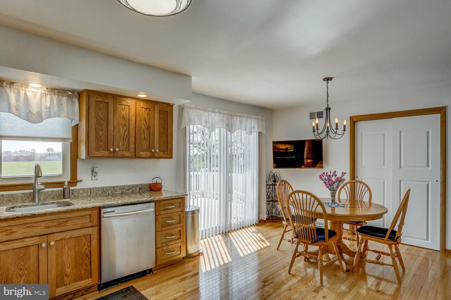 31 Trail Road South Elizabethtown, PA 17022 - Photo 11 of 40 a kitchen with stainless steel appliances granite countertop a stove top oven a sink a dining table and chairs with wooden floor