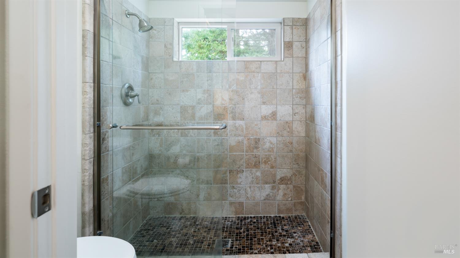 3335 Yulupa Avenue Santa Rosa, CA 95405 - Photo 25 of 33 Bright and inviting, the primary bathroom includes a modern tiled shower, perfectly complementing the custom vanity and sink.