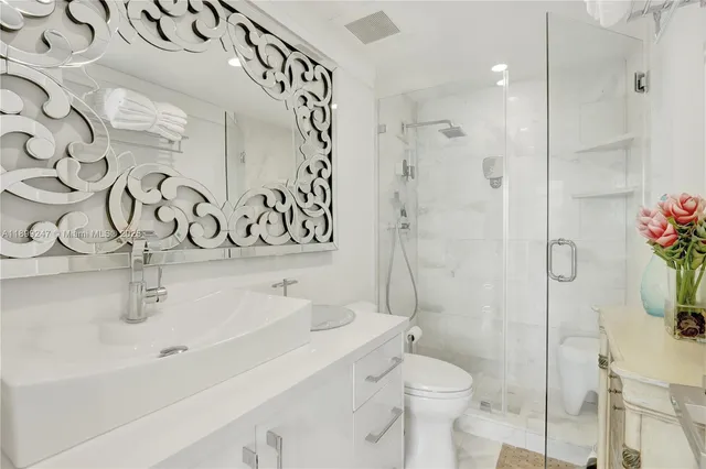 a bathroom with a sink and mirror with toilet