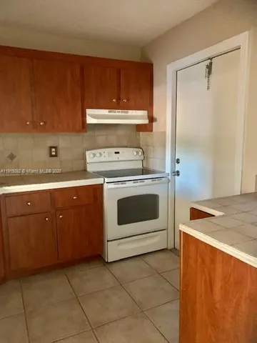 a kitchen with a stove sink and cabinets