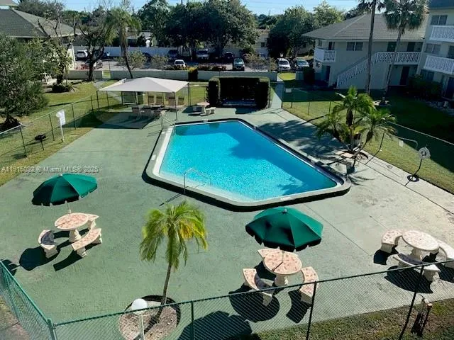 a view of a swimming pool with chairs potted plants