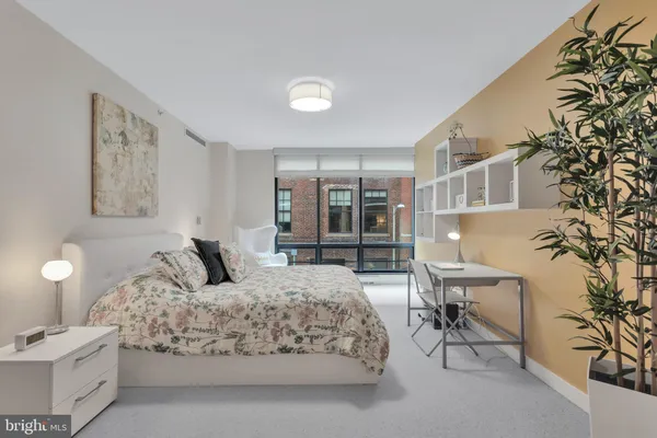 a bedroom with a large bed and a potted plant