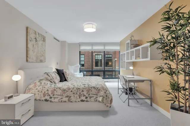 a bedroom with a large bed and a potted plant