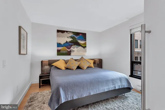 a bedroom with a bed and a painting on the wall