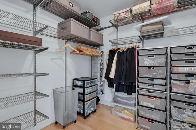 a view of walk in closet with clothes and shoes