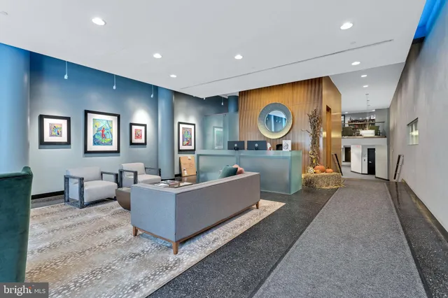 a living room with couches and kitchen view with wooden floor