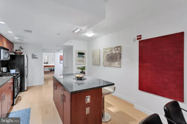 a kitchen with stainless steel appliances granite countertop a sink a stove and a refrigerator