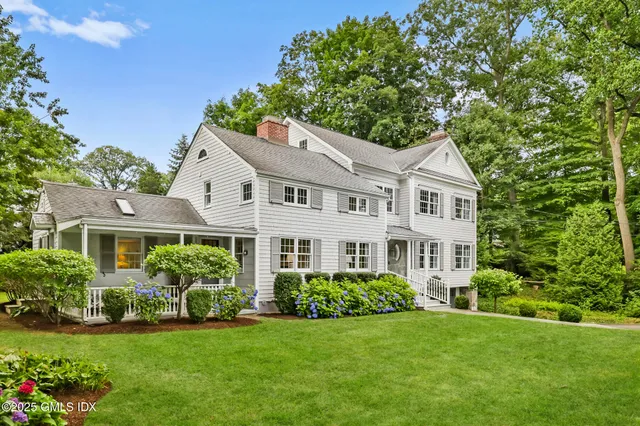 a front view of a house with a yard and green space